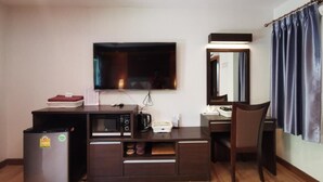 A compact hotel room with a kitchenette, a flat-screen TV, a desk with a chair, and a large mirror. - Hotel De Wualai-sha Extra Plus (Chiang Mai)