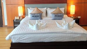 A neatly made bed with pillows labeled 'The Journey' and a swan-shaped pillow decoration. - Hotel De Wualai-sha Extra Plus (Chiang Mai)
