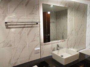 A modern bathroom with a marble backsplash, a large mirror, a sink, and a towel rack. - Hotel De Sripoom -sha Extra Plus (Chiang Mai)