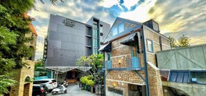 A modern building with a flat roof and a sign that reads 'BOOK'. - Book Design Hotel Sha Extra Plus (Chiang Mai)