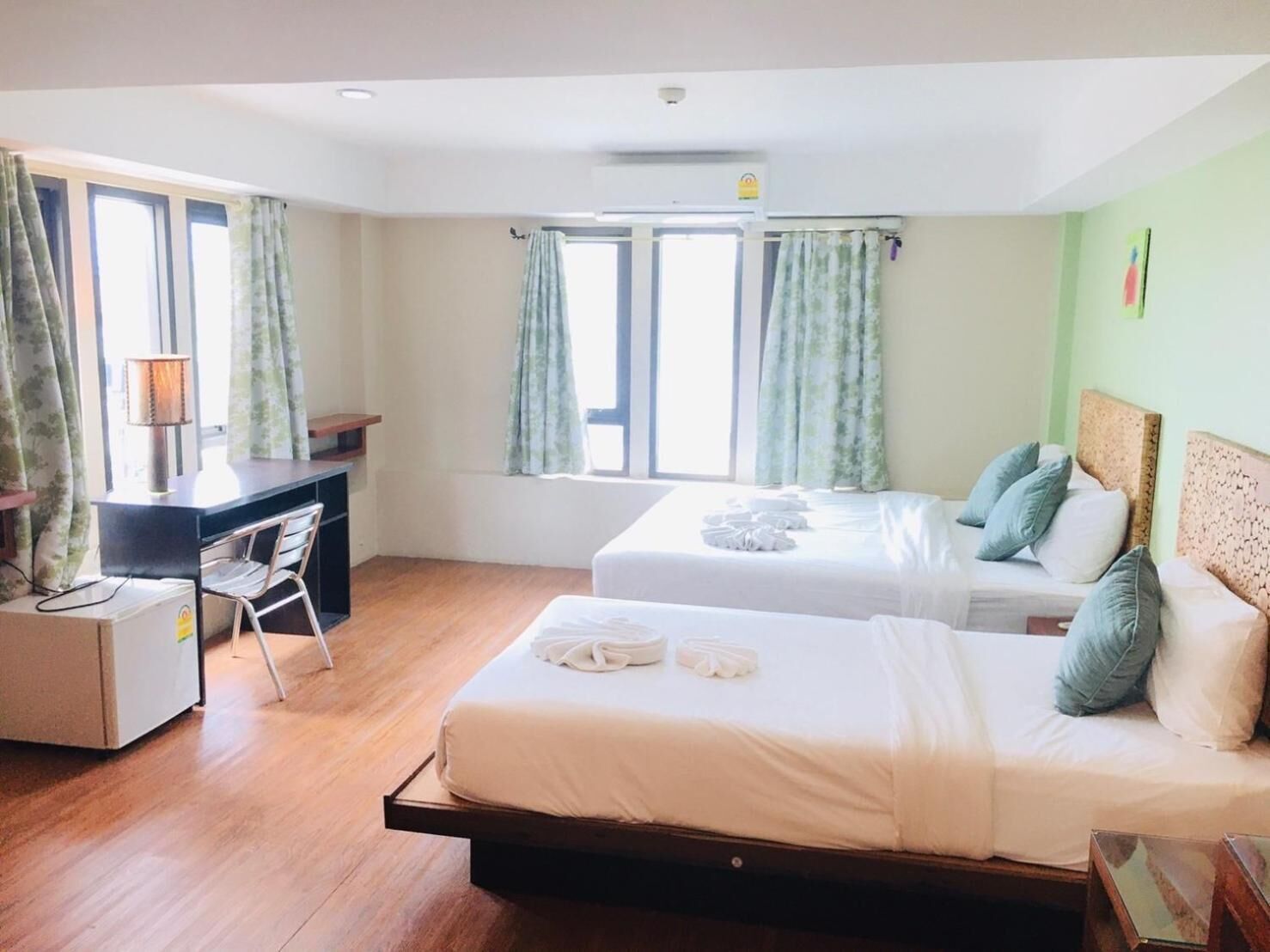 Une chambre d’hôtel avec deux lits, un bureau et une chaise.