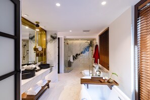 A modern bathroom with a marble vanity, a bathtub, and a glass shower enclosure.