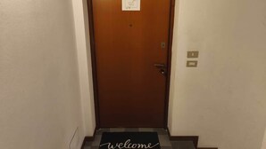 Una puerta de madera con un tapete de bienvenida en la entrada.