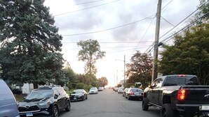 Eine Straße mit parkenden Autos und Bäumen.