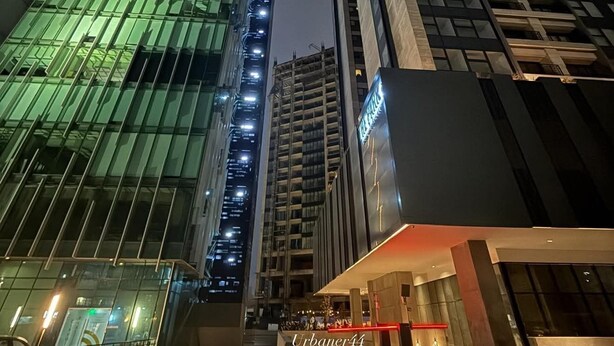 A modern urban building complex with glass facades and illuminated signage. - The Park Toreo 407. Modern apartment, private parking, Wi-Fi, great city views. (Tijuana)