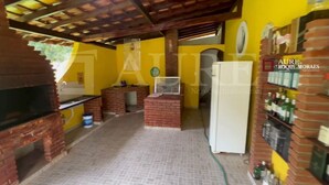 Une cuisine équipée d’un four à briques, d’un réfrigérateur et d’une étagère où sont rangées des bouteilles.