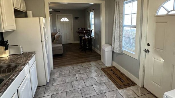 A kitchen with white cabinets, a granite countertop, and a tiled floor. - Red Brush Cottage Property (Elkton)