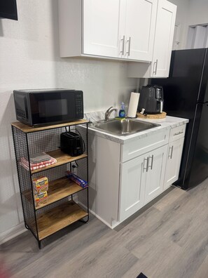 Fridge, microwave, coffee/tea maker, cookware/dishes/utensils