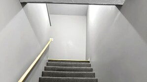 Una escalera con barandilla de madera que lleva a una plataforma.