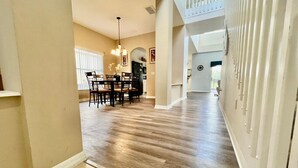 A spacious hallway with a wooden floor leading to a dining area with a table and chairs. - 1018 Wonderful House/ swimming pool and billiards (393266) (Davenport)