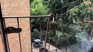 Una scala metallica conduce a un patio con mobili da esterno.