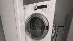 Kompakti, kaksipistekokoinen pyykinhuoltotila, jossa on sisäänrakennettu kuivausrumpu ja pesukone.