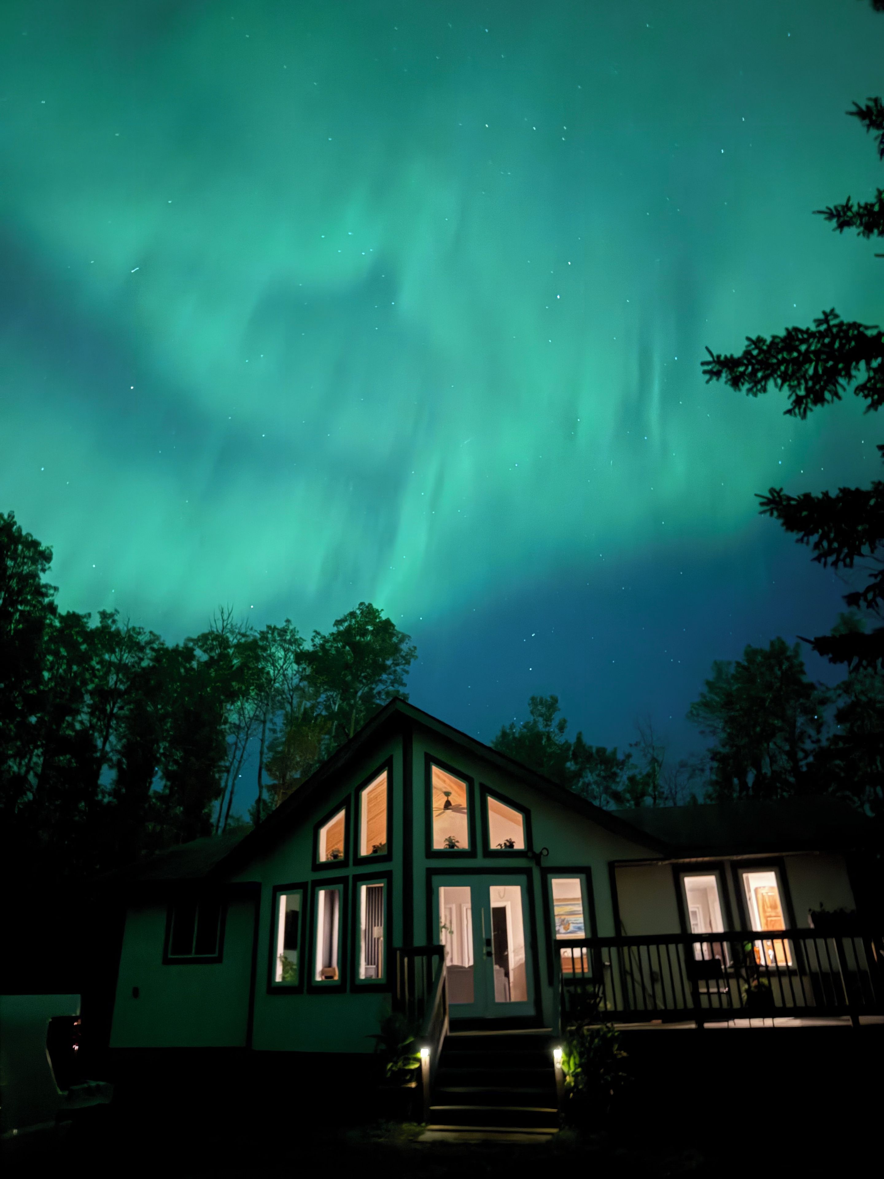 Una casa con veranda e numerose finestre, sotto un cielo notturno stellato.