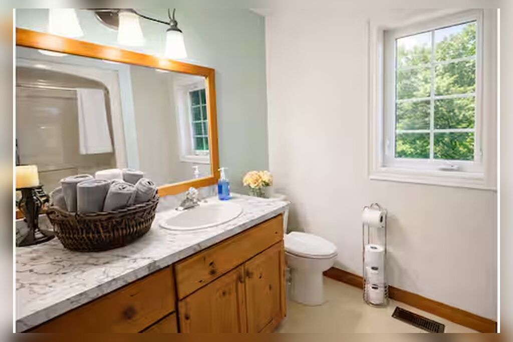 Ein Badezimmer mit Waschbecken, Spiegel und Toilette.