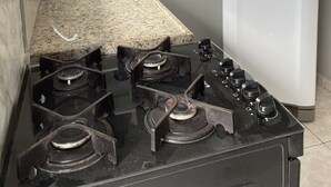 Une cuisine équipée d’une cuisinière à gaz, d’un évier, d’un réfrigérateur blanc et d’étagères remplies d’ustensiles de cuisine.