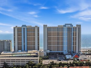 Ein Hochhaus-Hotel mit mehreren Etagen, einer Tiefgarage und Blick auf den Strand.