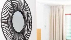 Un saló modern amb un sofà blau, una taula de centre i un mirall decoratiu a la paret.