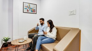 A modern room with a sofa, a small round table, and a potted plant.