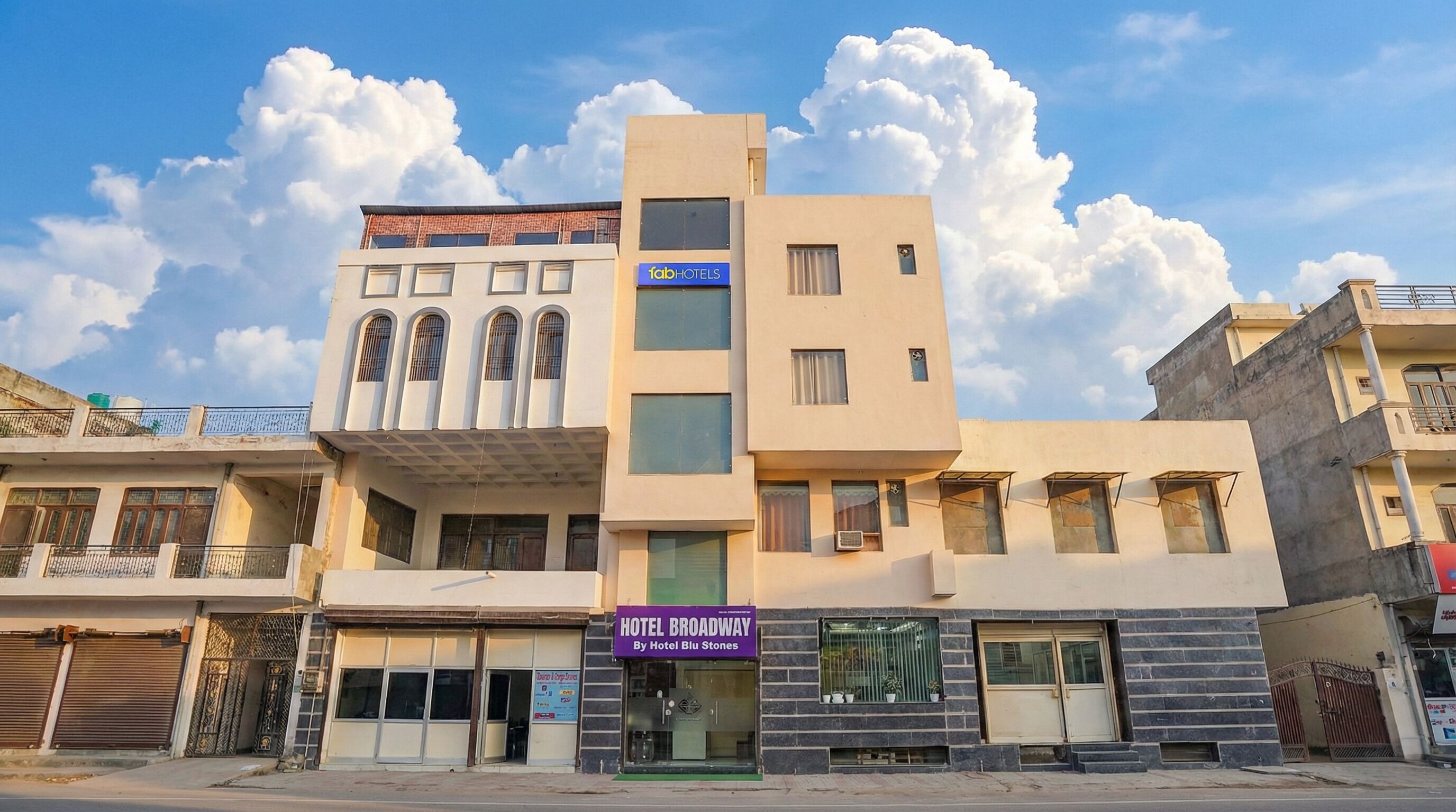 A multi-story hotel with a modern facade, including a prominent 'fabHOTELS' sign.