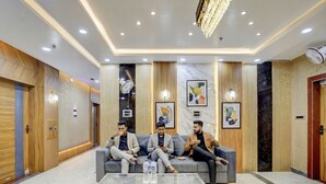 Un vestíbul modern amb zona de seients, una taula de cafè de vidre i un penjall.
