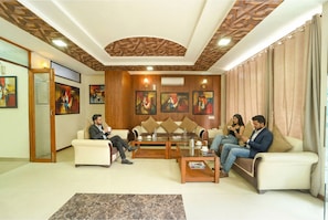 A modern living room with a sofa set, coffee table, and artwork on the walls.
