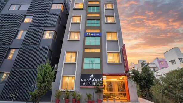 Un edificio moderno con un letrero que dice 'fabHOTELS' y 'A1 SUITES'.