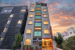 A modern building with a sign for 'fabHOTELS' and 'A1 SUITES'. - Via A1 Suites (Bangalore)