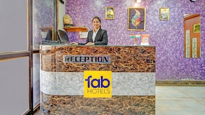 A reception desk with a marble top and a sign reading "FAB HOTELS RECEPTION". - Fabhotel Sandalwood Vibes (Bhopal)