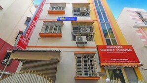 Un immeuble à plusieurs étages, sur lequel on peut voir une enseigne indiquant « Crown Guest House », ce qui signifie que des chambres sont disponibles à la réservation.