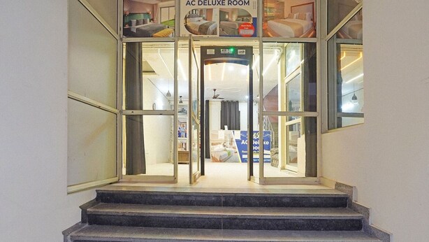 A hotel entrance with a glass door, a sign above the door reading "AC DELUXE ROOM," and a staircase leading up to the entrance. - Fabhotel Rose Residency (New Delhi)