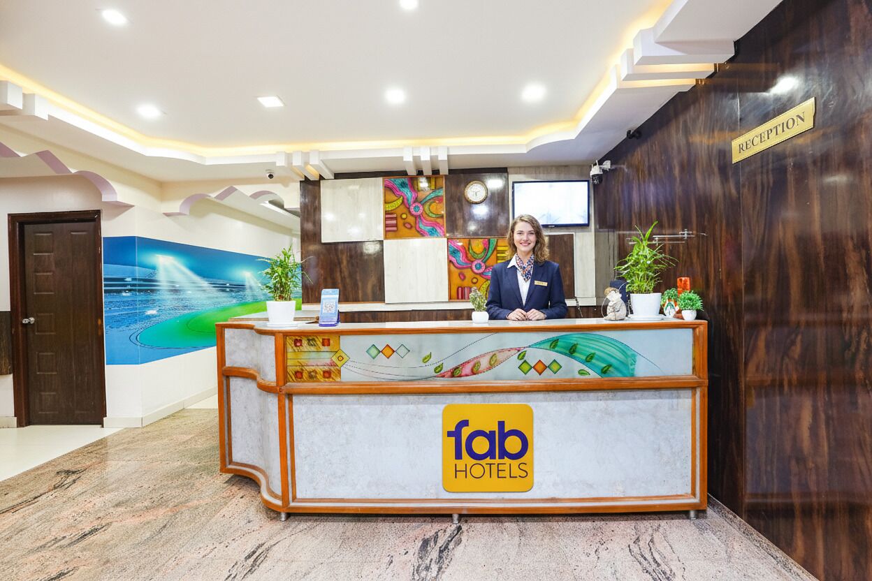 A hotel reception desk with a modern design, a clock, and a reception sign.