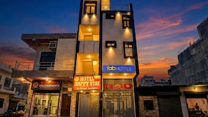 A multi-story hotel with a sign for 'Hotel Happy Stay' and 'Fab Hotels'. - Fabhotel Happy Stay I (Noida)