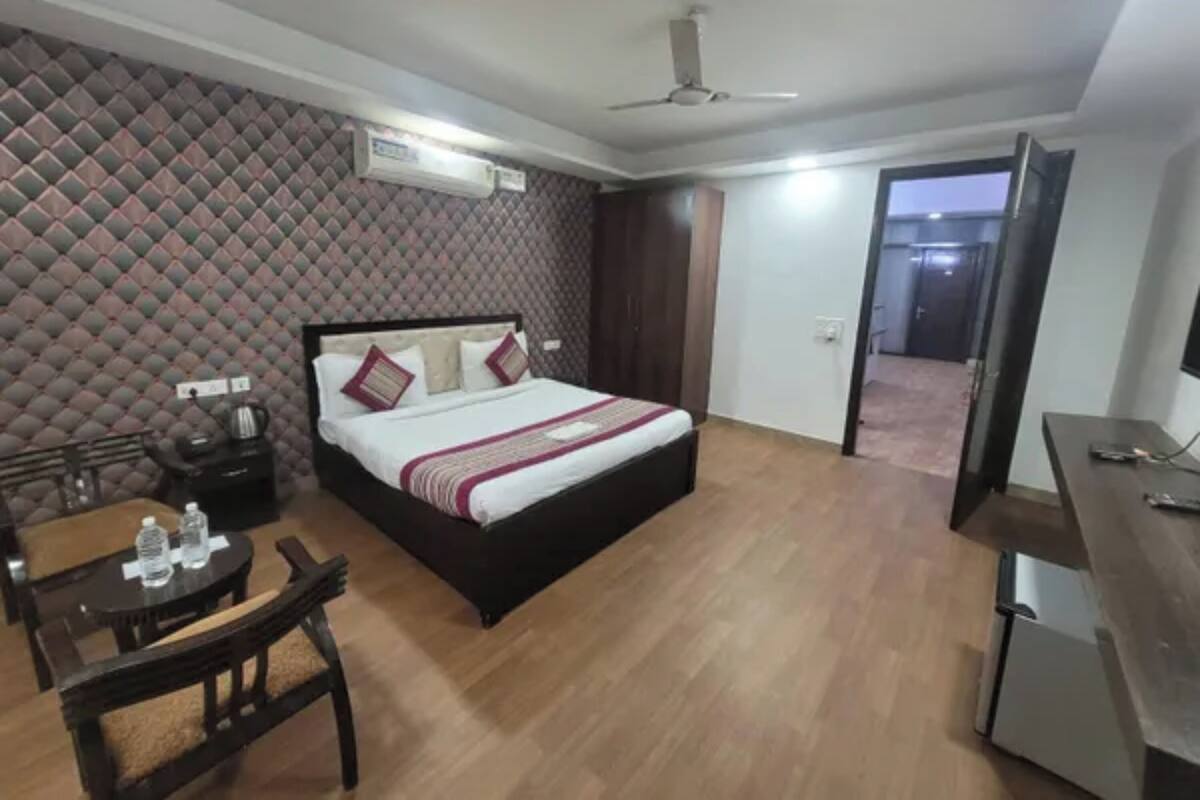 Una camera d'albergo con un letto, una scrivania, una sedia e una televisione.