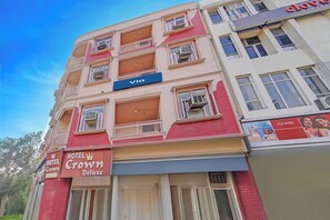 A multi-story building with a 'Hotel Crown Deluxe' sign, a 'Via' sign, and a 'Mars' advertisement. - Via Crown DX (New Delhi)
