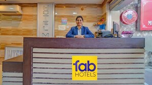 A hotel reception desk with a sign reading "fab hotels" and a "hotel" sign on the wall. - Fabhotel Mj International (Lucknow)