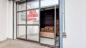 Eine Hotelrezeption, auf der ein Schild mit dem Schriftzug 'Motel Rustic Roots Reception' steht.