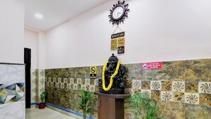 A reception area with a statue of a deity, a clock, and a sign with 'Rules of Life'. - Fabhotel Springwood (Barasat)
