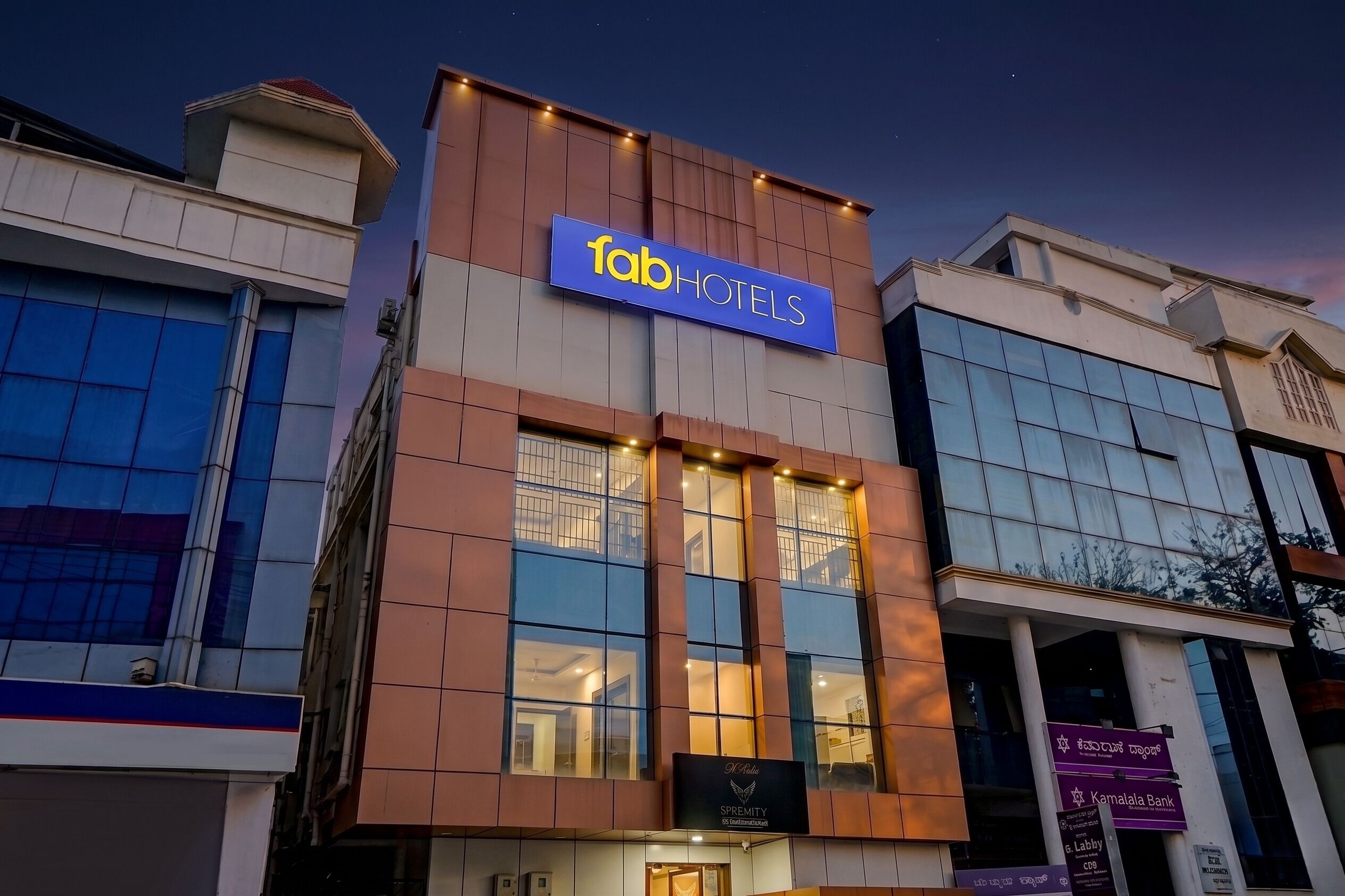 A building with a sign reading 'fab hotels' and a sign for 'Karnataka Bank' below it.