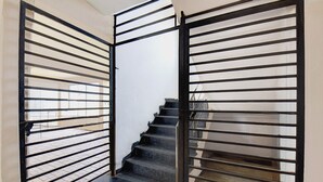 A staircase with metal railings leading to an upper floor. - Via Royal Stay I (Pune)