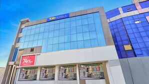A hotel with a large glass facade, a prominent 'fab hotels' sign, and a sale sign advertising up to 74% off. - Fabhotel Satya (Noida)