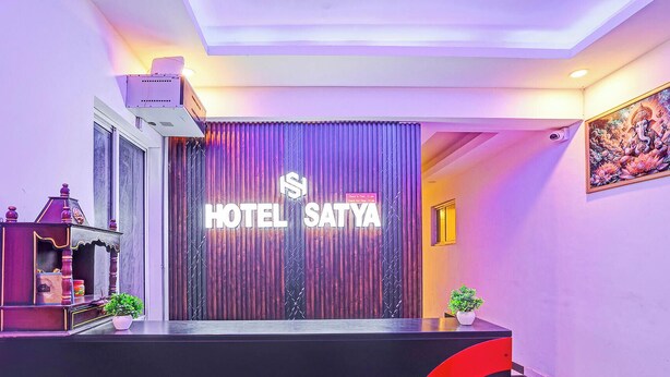 A hotel reception area with a large illuminated sign reading "HOTEL SATYA". - Fabhotel Satya (Noida)