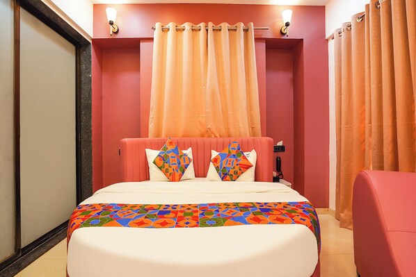 A hotel room with a bed, two pillows, a headboard, a nightstand, a lamp, and curtains. - Via The Business (Pune)