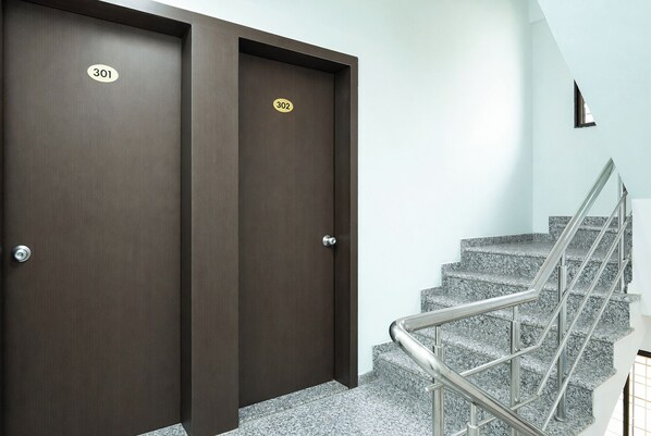 A set of double doors with room numbers 301 and 302, a staircase with metal railings, and a light-colored wall. - Via The Business (Pune)
