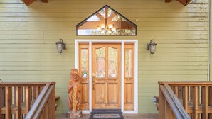 A wooden front porch with a welcome sign, a wooden door with glass panels, and a wooden railing. - Relax in Kings Beach Canterbury Pines- 3BR with Hot tub! (Kings Beach)
