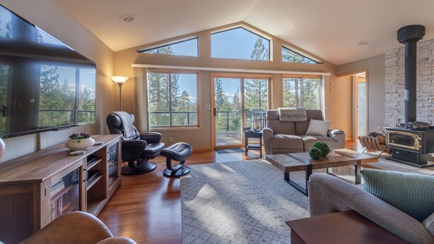 A spacious living room with a high ceiling, large windows, a fireplace, and a cozy seating area. - Relax in Kings Beach Canterbury Pines- 3BR with Hot tub! (Kings Beach)