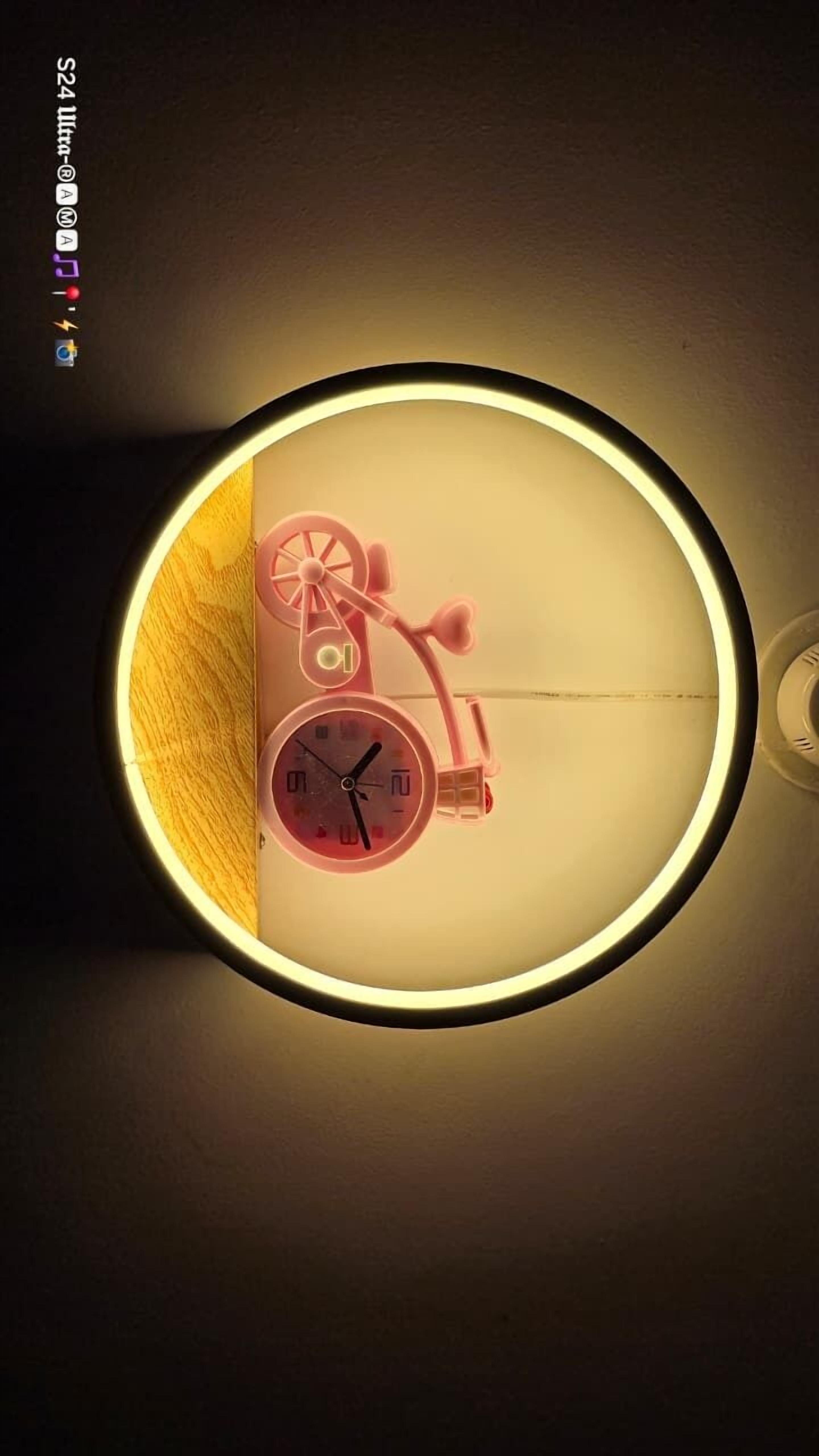 Un reloj de pared con diseño de bicicleta, que presenta una esfera circular grande y un segundero pequeño.