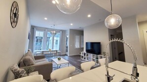 Un salon moderne avec un canapé, une table à manger et un téléviseur.
