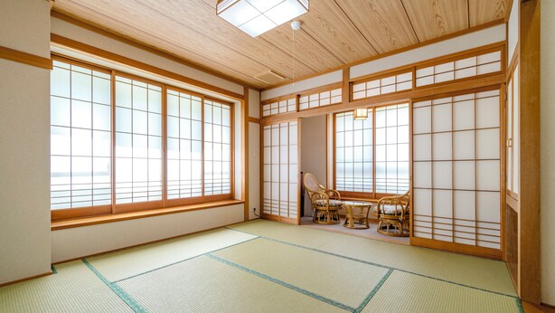A traditional Japanese room with tatami flooring, sliding doors, and a view through large windows. - Onsen Oyado Ruribitaki (Matsumoto)