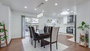 A modern kitchen with a dining area, featuring a large table, chairs, and built-in appliances.