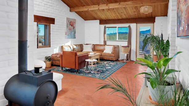 A spacious living area with a high ceiling, wooden beams, and large windows. - Casa de Kiva - your Cochise County Escape (Cochise)